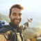 Shot of a young man taking selfies while hiking up a mountain